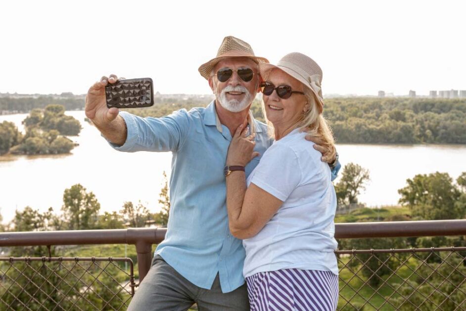 Senior couple capturing travel memories using smartphone while sightseeing