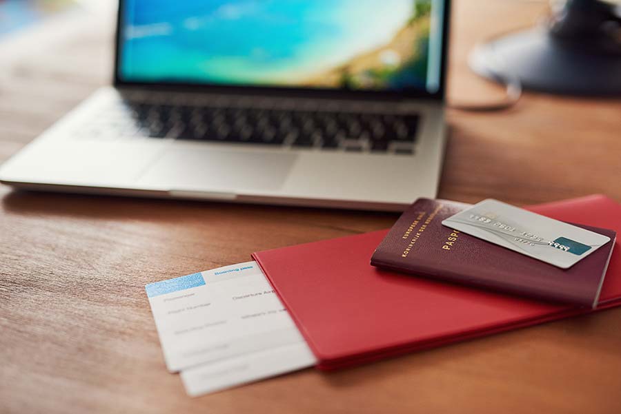 remote work and travel planning with laptop, passport, and flight ticket