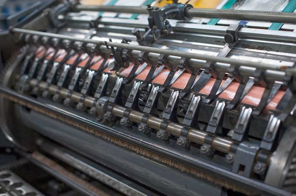 Web offset printing machine rollers handling continuous paper feed during production.