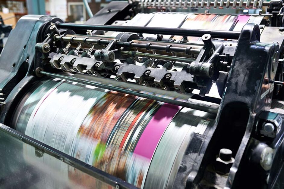 Continuous feed web offset printing process running at industrial production speed.