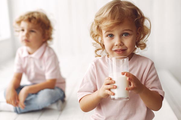 Drinking Milk: Happy child enjoying easily digestible lactose-free goodness with a smile.