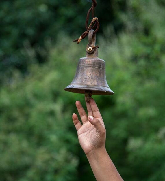hand ringing big bell temple outdoors