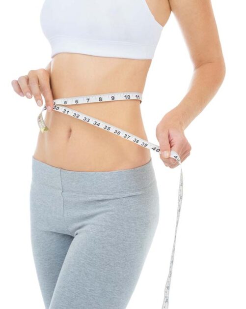 Person measuring waist, celebrating progress towards a healthy eating habits