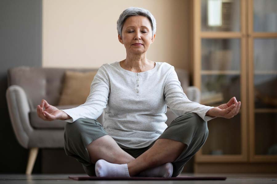 Woman meditating at home, focusing on relaxation and stress management