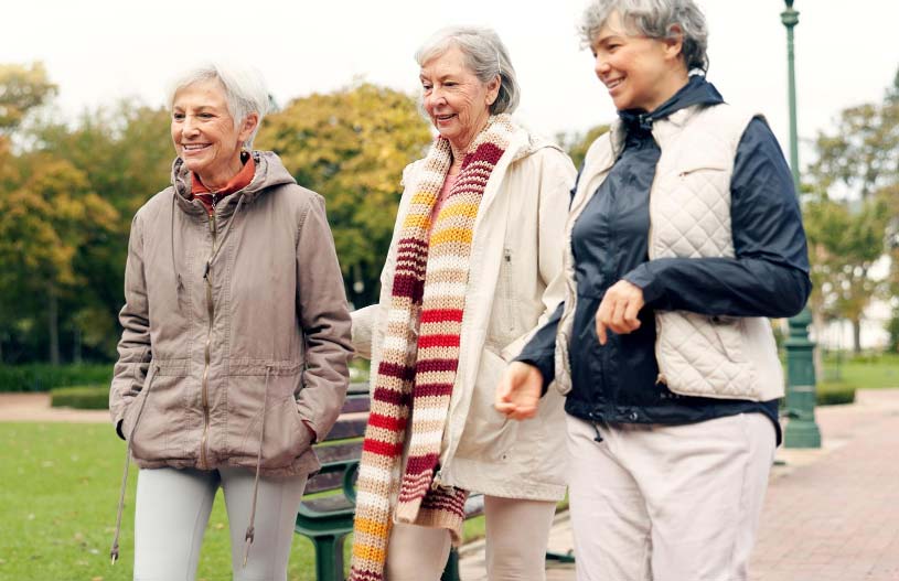 Women walking outdoors, supporting each other’s fitness journey.