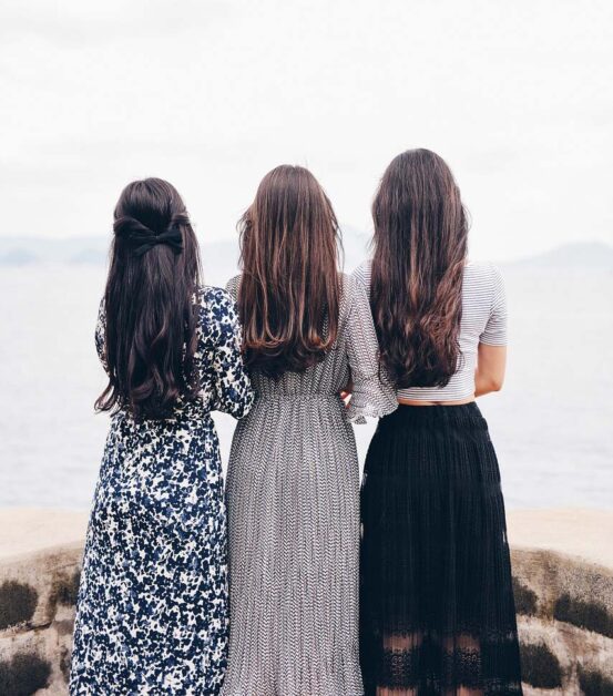 Group of women laughing together, enjoying social connections outdoors.