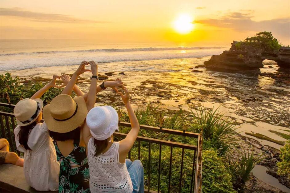 Tourists enjoy a breathtaking sunset at Tanah Lot, Bali