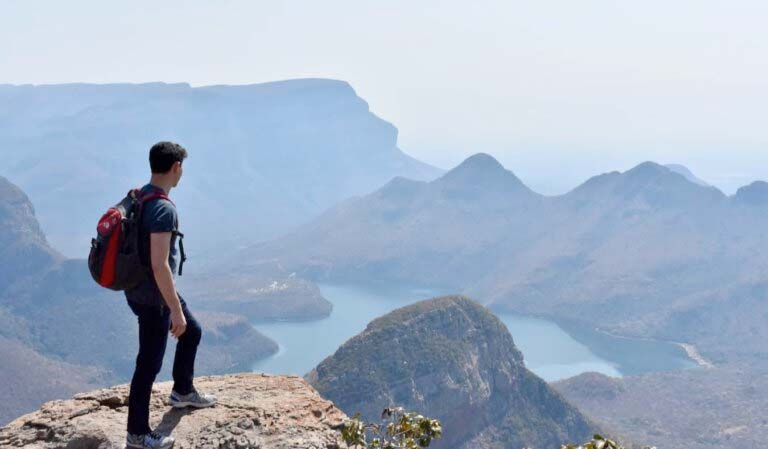 Travel Influencer (Nomadic Matt) standing atop a scenic mountain view