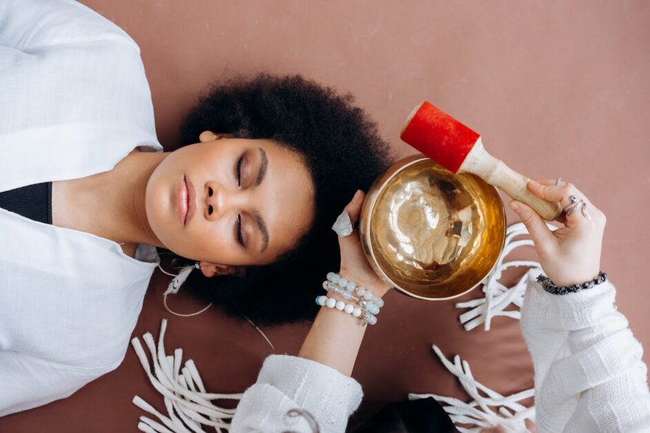 Person using a Tibetan singing bowl for chakra healing.