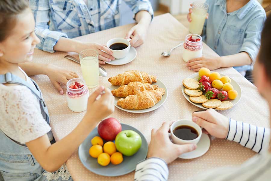 Family enjoying a balanced breakfast with fruits and pastries