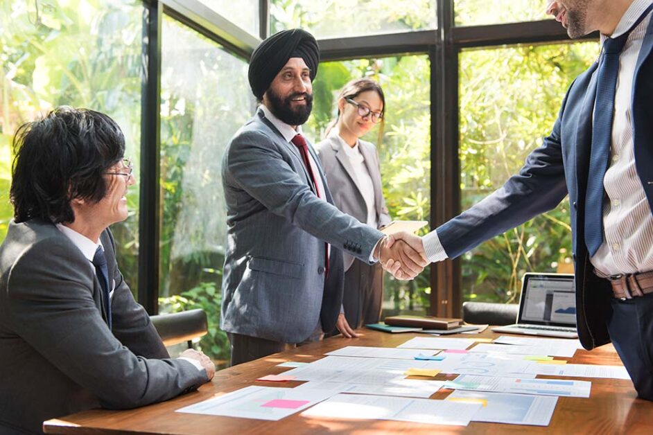 Business professionals shaking hands, symbolizing India-Canada trade relations