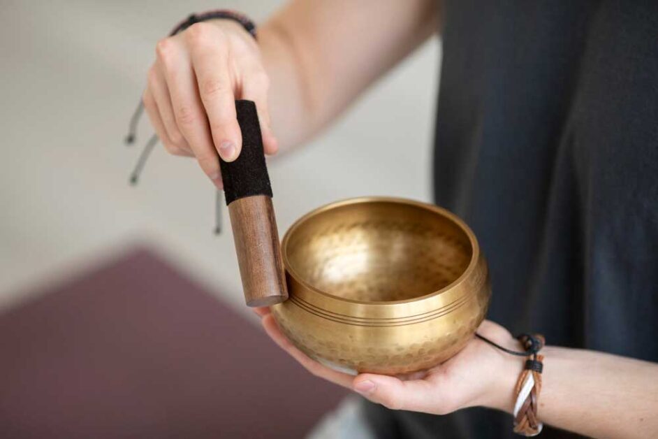 Spiritual practitioner using a singing bowl for mindfulness.