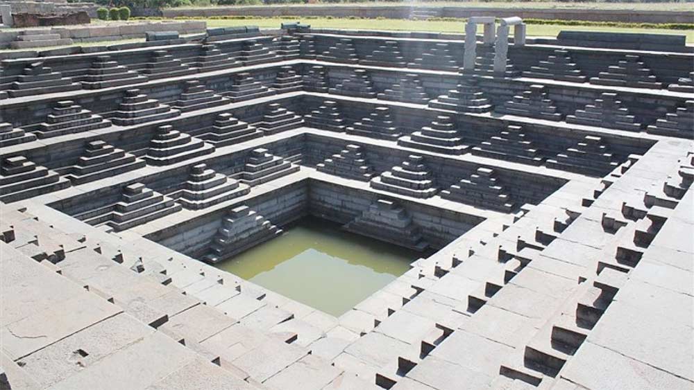 Symmetrical Pushkarani Stepwell in Hampi, Karnataka, showcasing Vijayanagara architecture.