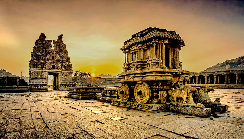 Ancient Stone Chariot at Vittala Temple, Hampi, during sunset.