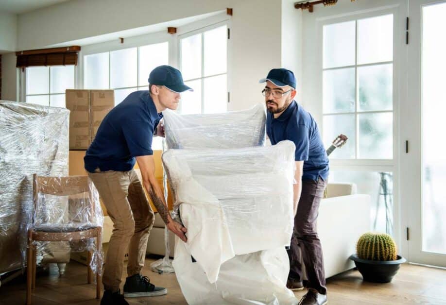 Junk removal team lifting packed furniture during a compassionate house cleanout