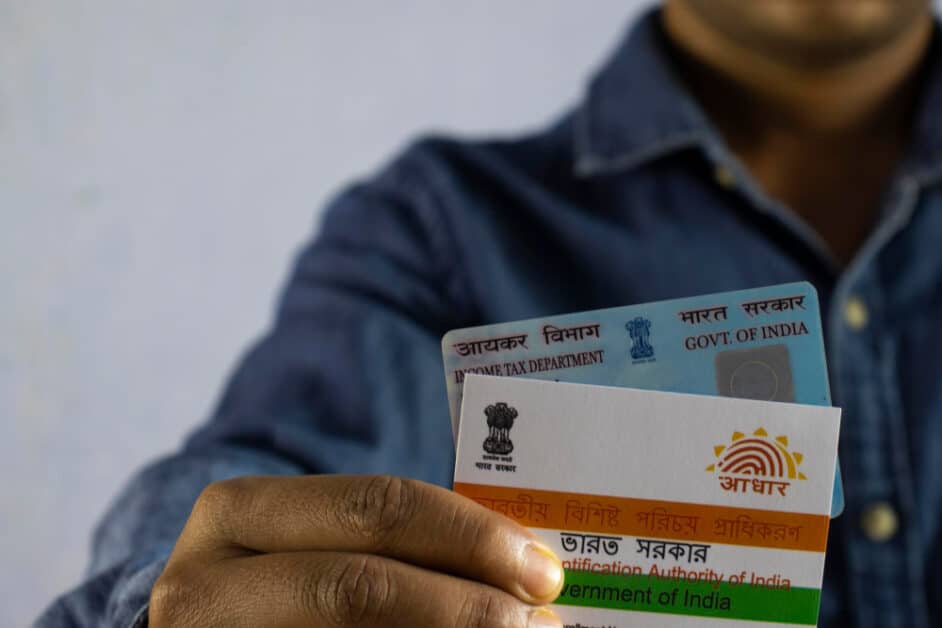 Person holding Aadhaar and PAN cards- mandatory linkage