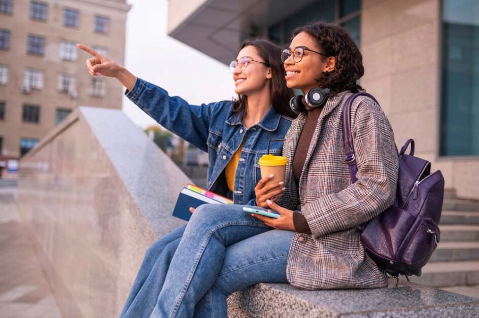 Two students sitting outside discussing international education opportunities