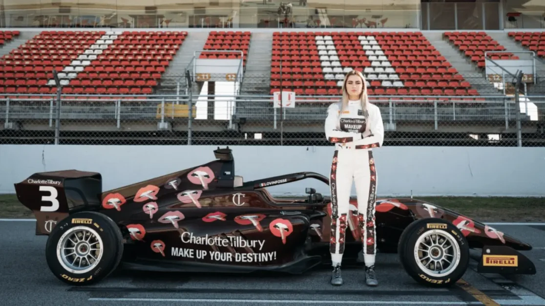 Female race car driver standing beside Charlotte Tilbury–branded Formula car