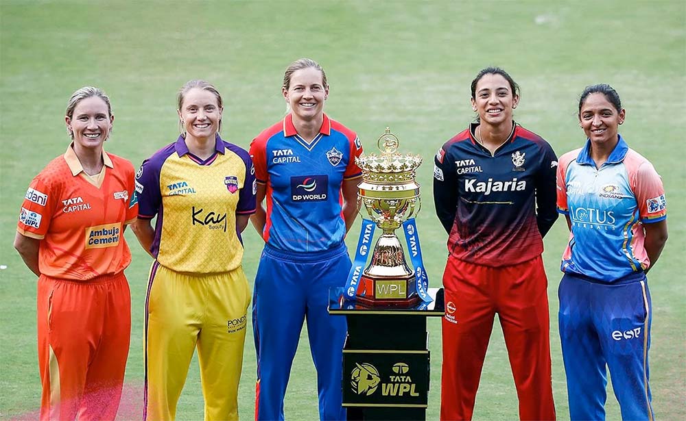 Women’s Premier League team captains standing beside the championship trophy on field